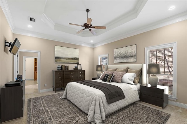 bedroom with carpet flooring, a tray ceiling, ceiling fan, and crown molding