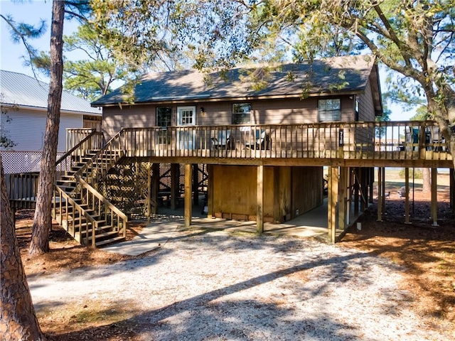 rear view of house featuring a wooden deck and stairs