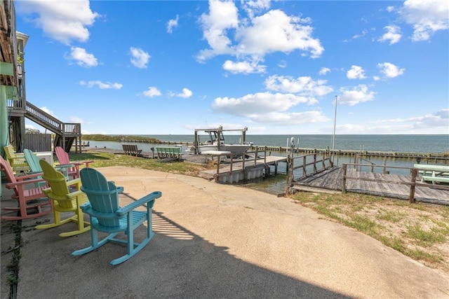 view of patio with a boat dock and a water view