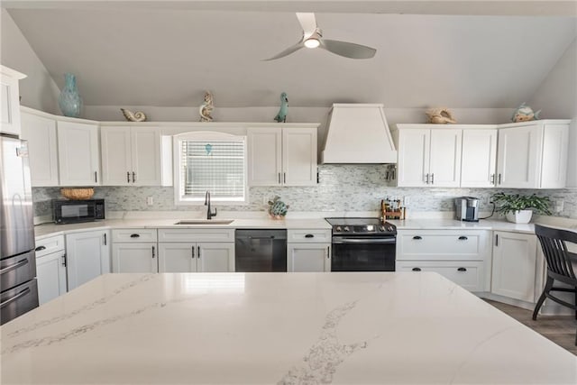 kitchen featuring ceiling fan, white cabinets, premium range hood, sink, and black appliances