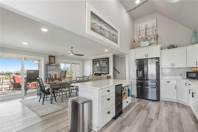 kitchen featuring ceiling fan, light hardwood / wood-style flooring, stainless steel fridge, and white cabinetry