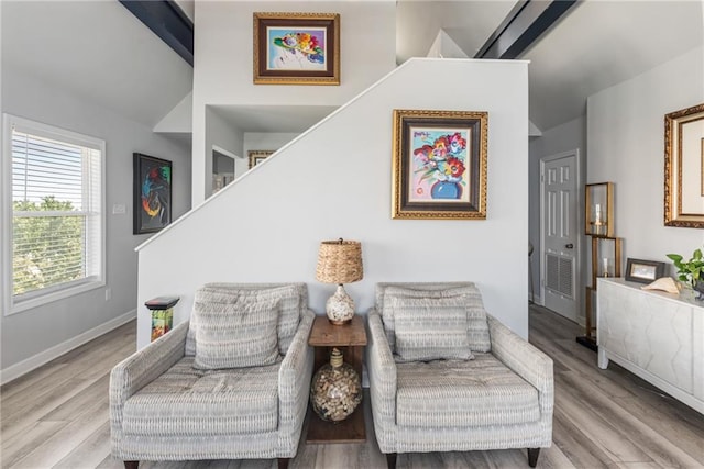 sitting room featuring beamed ceiling and light hardwood / wood-style flooring