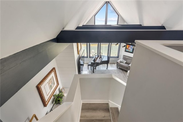 stairs featuring wood-type flooring and vaulted ceiling