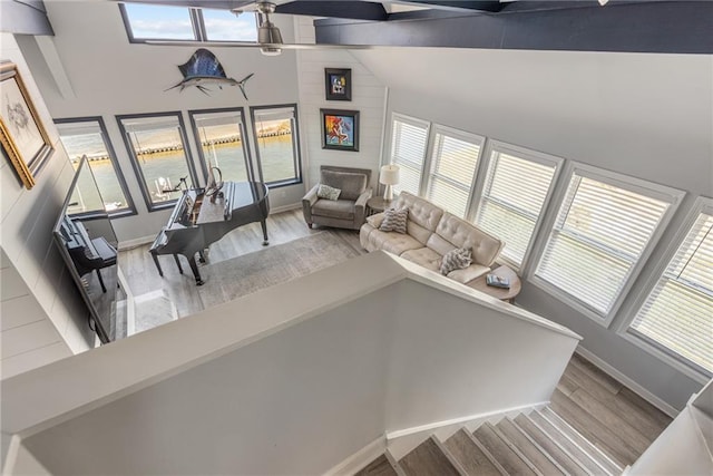 stairway featuring high vaulted ceiling and hardwood / wood-style flooring