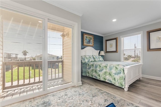 bedroom featuring wood-type flooring, access to exterior, and multiple windows