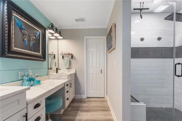 bathroom featuring wood-type flooring, walk in shower, vanity, and crown molding