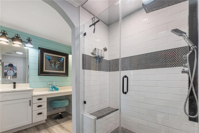 bathroom featuring walk in shower, wood-type flooring, and vanity