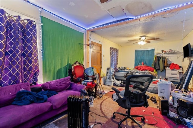 interior space with ceiling fan, carpet flooring, and a textured ceiling