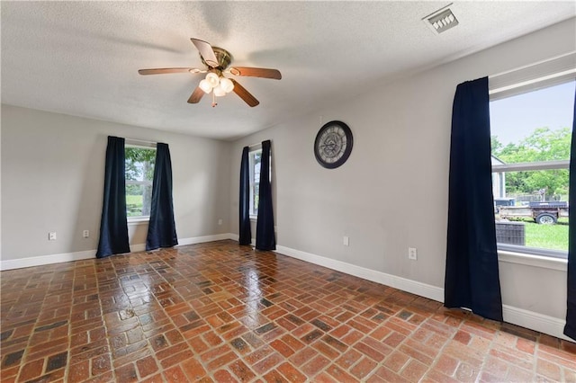 spare room with ceiling fan and a textured ceiling