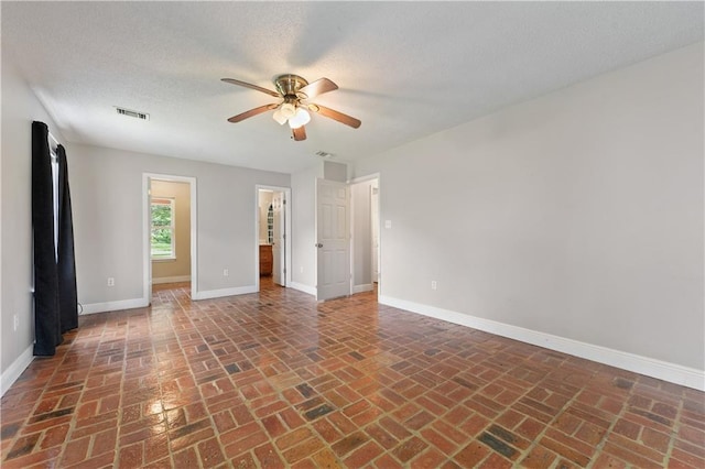 unfurnished room featuring ceiling fan and a textured ceiling