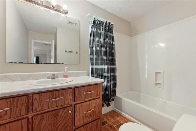 full bathroom featuring shower / bathtub combination with curtain, a textured ceiling, toilet, and vanity with extensive cabinet space