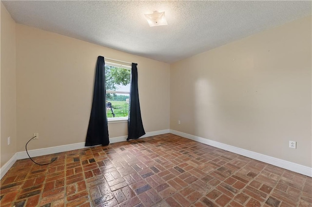 unfurnished room with a textured ceiling