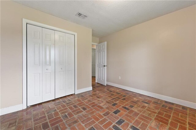 unfurnished bedroom featuring a closet and a textured ceiling