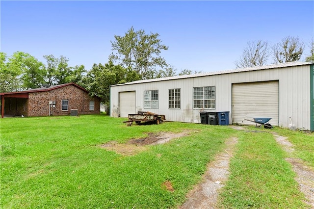 rear view of property featuring a garage and a lawn