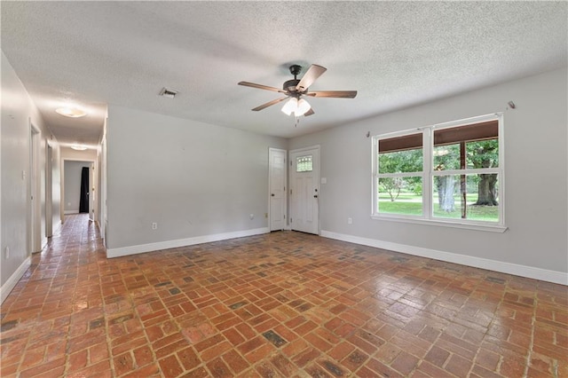 spare room featuring ceiling fan and a textured ceiling