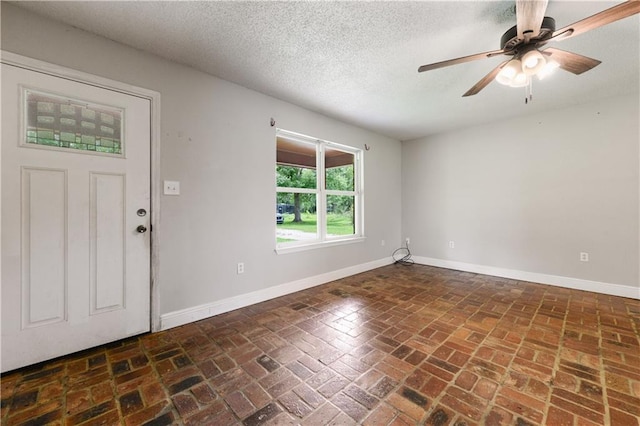 foyer featuring ceiling fan and a textured ceiling