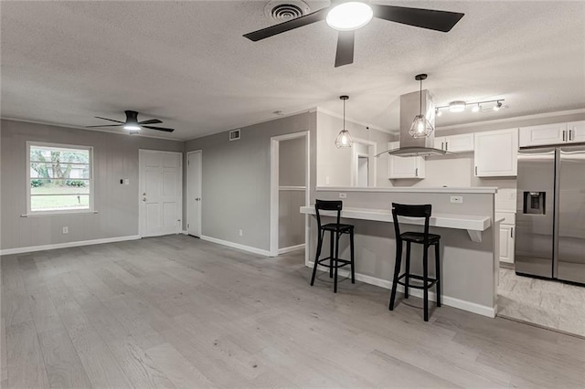 kitchen featuring white cabinetry, ceiling fan, stainless steel fridge with ice dispenser, light hardwood / wood-style floors, and a breakfast bar