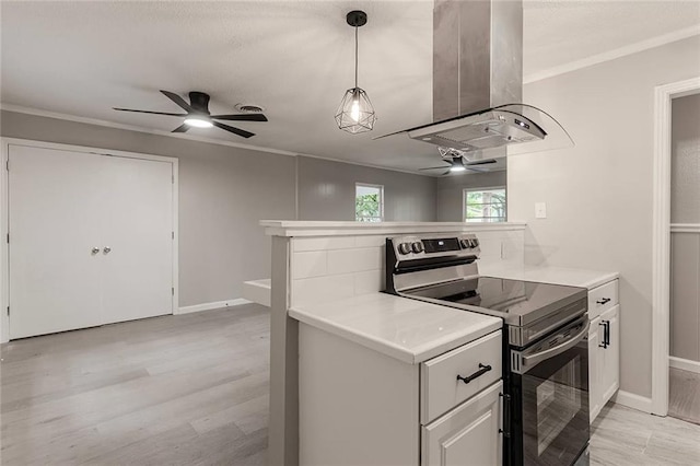 kitchen featuring kitchen peninsula, white cabinetry, island range hood, and stainless steel electric range