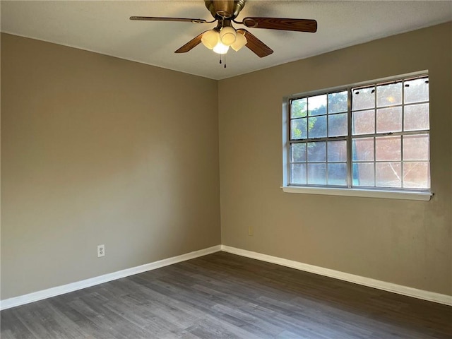 empty room featuring dark hardwood / wood-style flooring, a wealth of natural light, and ceiling fan