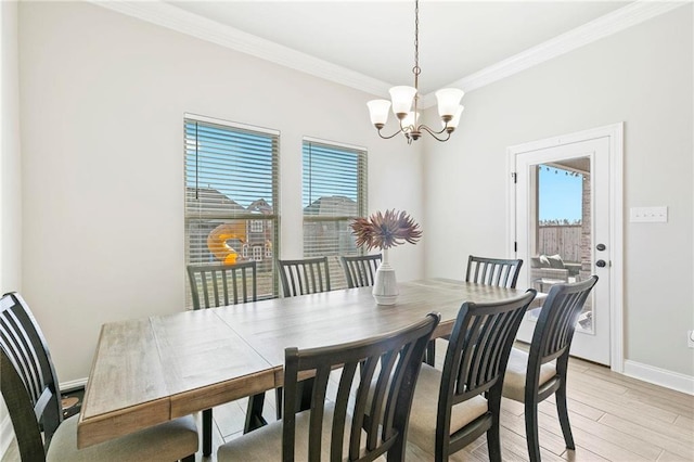 dining space featuring a chandelier, plenty of natural light, light hardwood / wood-style floors, and ornamental molding