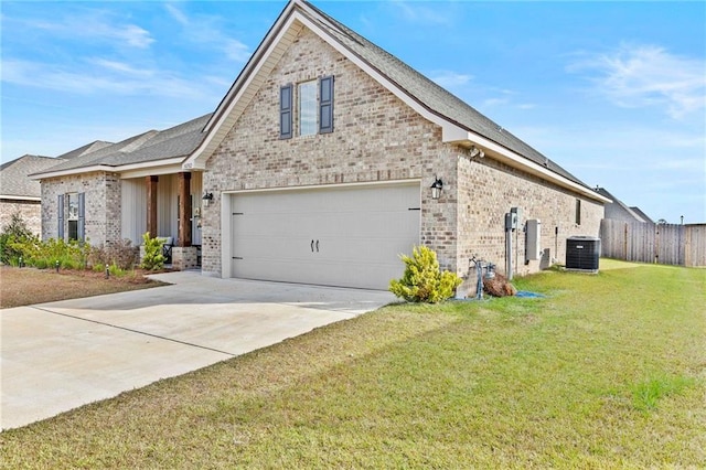 view of front of property with a garage, central AC unit, and a front yard