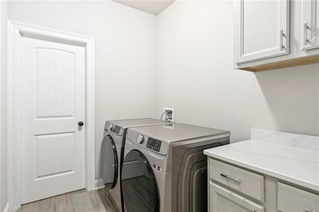 washroom featuring cabinets, independent washer and dryer, and light wood-type flooring