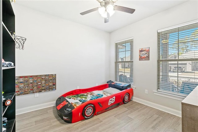 bedroom featuring light hardwood / wood-style floors, multiple windows, and ceiling fan