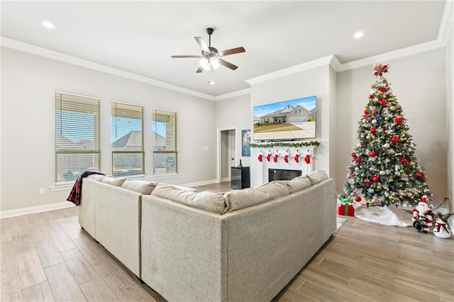 living room with light hardwood / wood-style flooring, ornamental molding, and ceiling fan