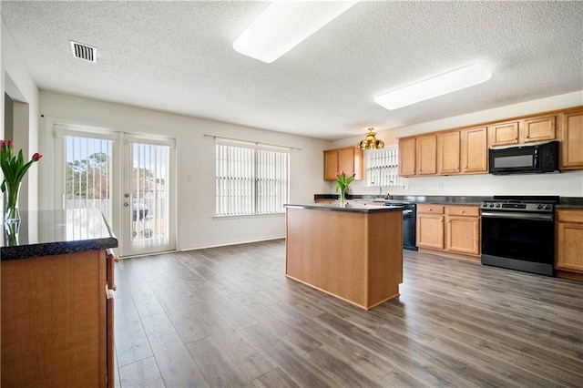 kitchen featuring dark hardwood / wood-style flooring, a center island, black appliances, a textured ceiling, and french doors