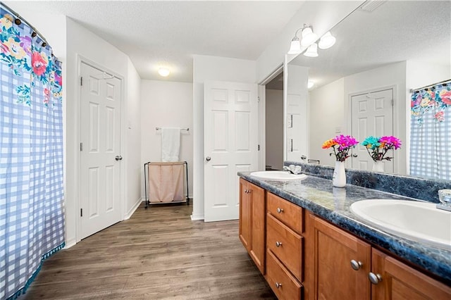 bathroom with hardwood / wood-style flooring, vanity, and a textured ceiling