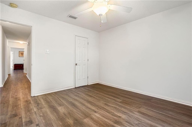 spare room with dark hardwood / wood-style floors and ceiling fan