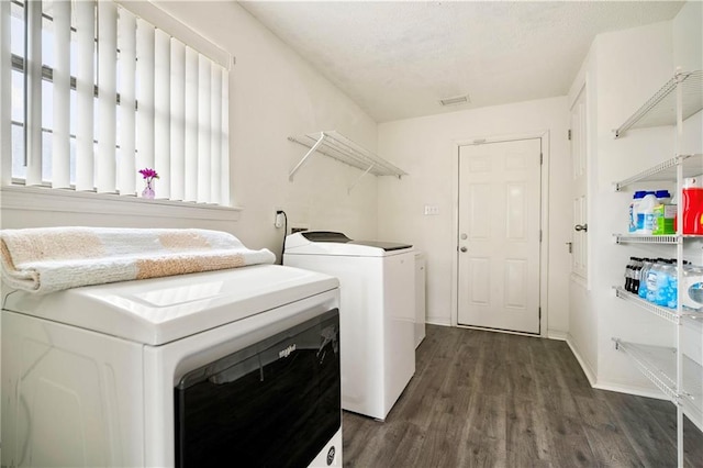 laundry area with independent washer and dryer and dark hardwood / wood-style flooring