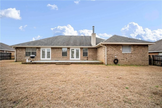 back of property with french doors, a yard, and a patio