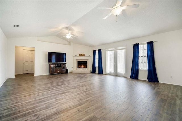 unfurnished living room featuring a tiled fireplace, ceiling fan, lofted ceiling, and dark hardwood / wood-style flooring