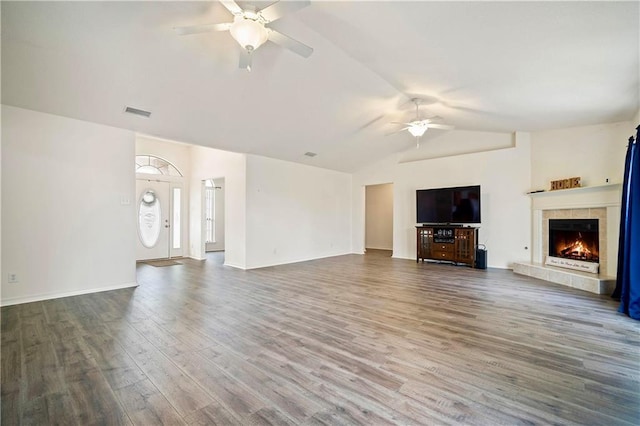 unfurnished living room featuring lofted ceiling, wood-type flooring, a fireplace, and ceiling fan