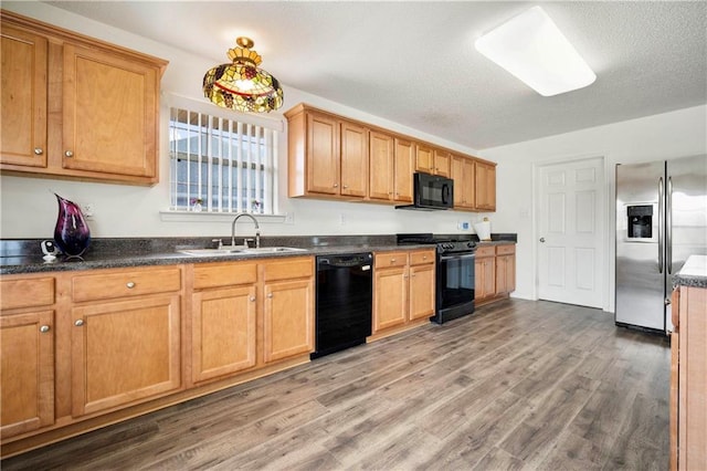 kitchen with sink, dark wood-type flooring, a textured ceiling, and black appliances