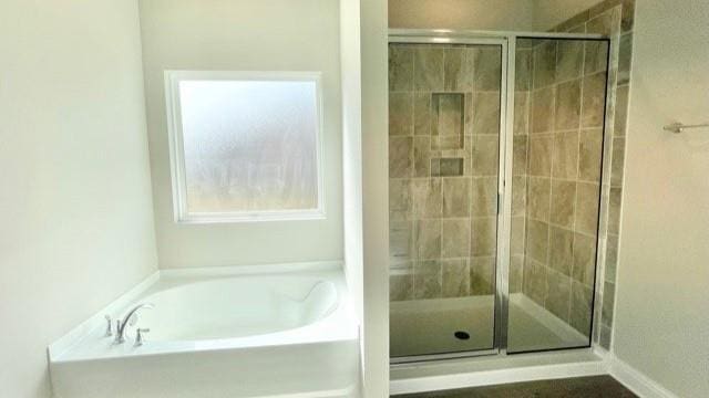 bathroom featuring shower with separate bathtub