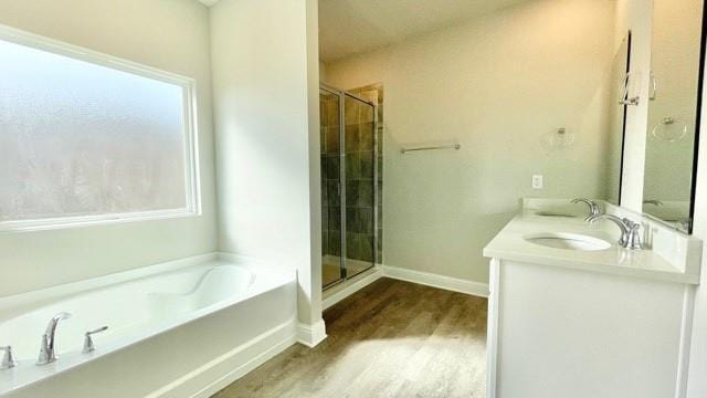 bathroom featuring vanity, hardwood / wood-style floors, and plus walk in shower