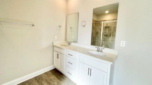 bathroom with a shower with door, vanity, and hardwood / wood-style floors