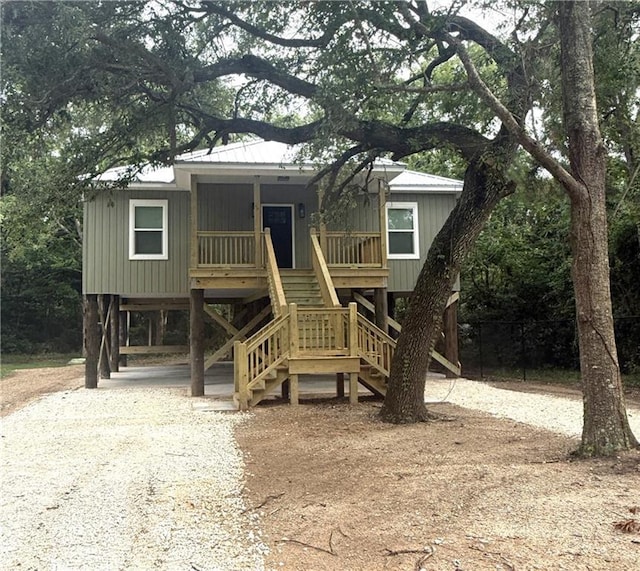 755 Cadillac Ave, Dauphin Island, AL 36528 - beach home featuring a carport, covered porch, stairway, dirt driveway, and a metal roof
