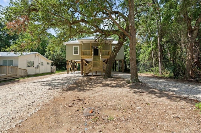 755 Cadillac Ave, Dauphin Island, AL 36528 - view of front of house featuring stairs, driveway, a carport, and covered porch