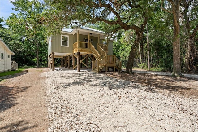 755 Cadillac Ave, Dauphin Island, AL 36528 - view of front of home featuring stairs, a carport, dirt driveway, a porch, and a metal roof