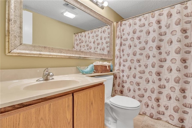 25293 Perdido Beach Blvd Unit 2, Orange Beach, AL 36561 - full bath with visible vents, toilet, vanity, and a textured ceiling