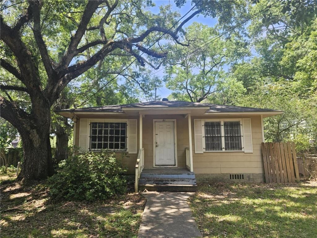 bungalow-style home featuring fence and crawl space