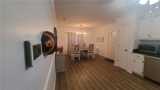 dining area with a chandelier, crown molding, and dark wood-type flooring