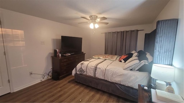 bedroom with dark hardwood / wood-style flooring and ceiling fan