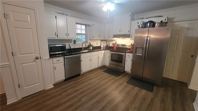 kitchen featuring appliances with stainless steel finishes, ornamental molding, dark wood-type flooring, and white cabinetry