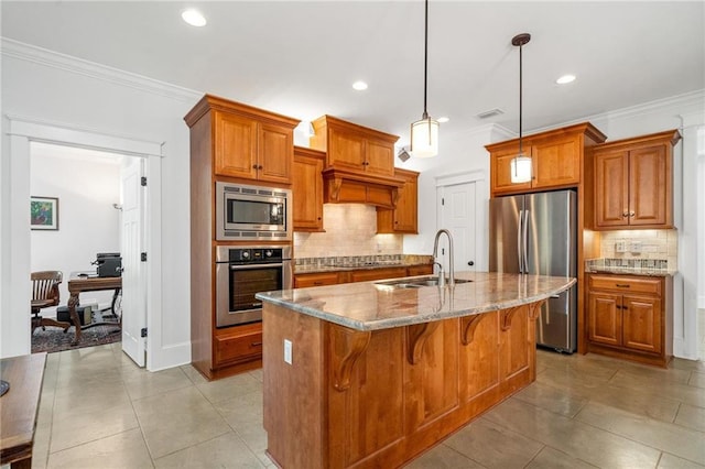 kitchen featuring sink, stainless steel appliances, light stone countertops, a center island with sink, and decorative light fixtures