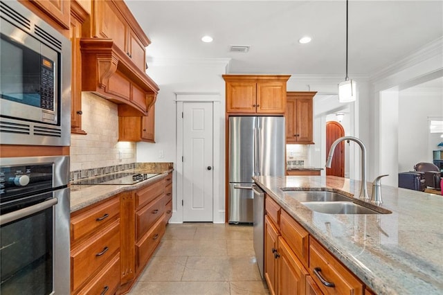 kitchen featuring sink, hanging light fixtures, ornamental molding, stainless steel appliances, and light stone countertops