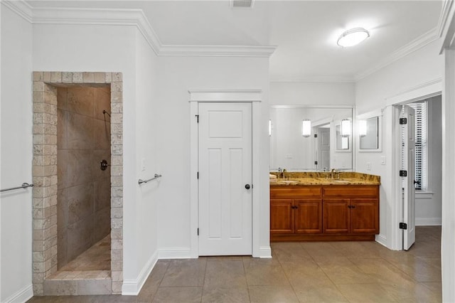 bathroom with crown molding, a tile shower, vanity, and tile patterned floors